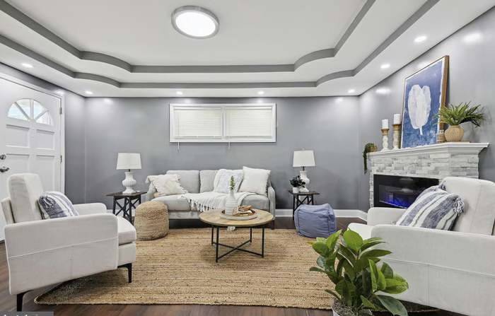 Living room with light gray walls, white furniture and electric fireplace in Newark, NY