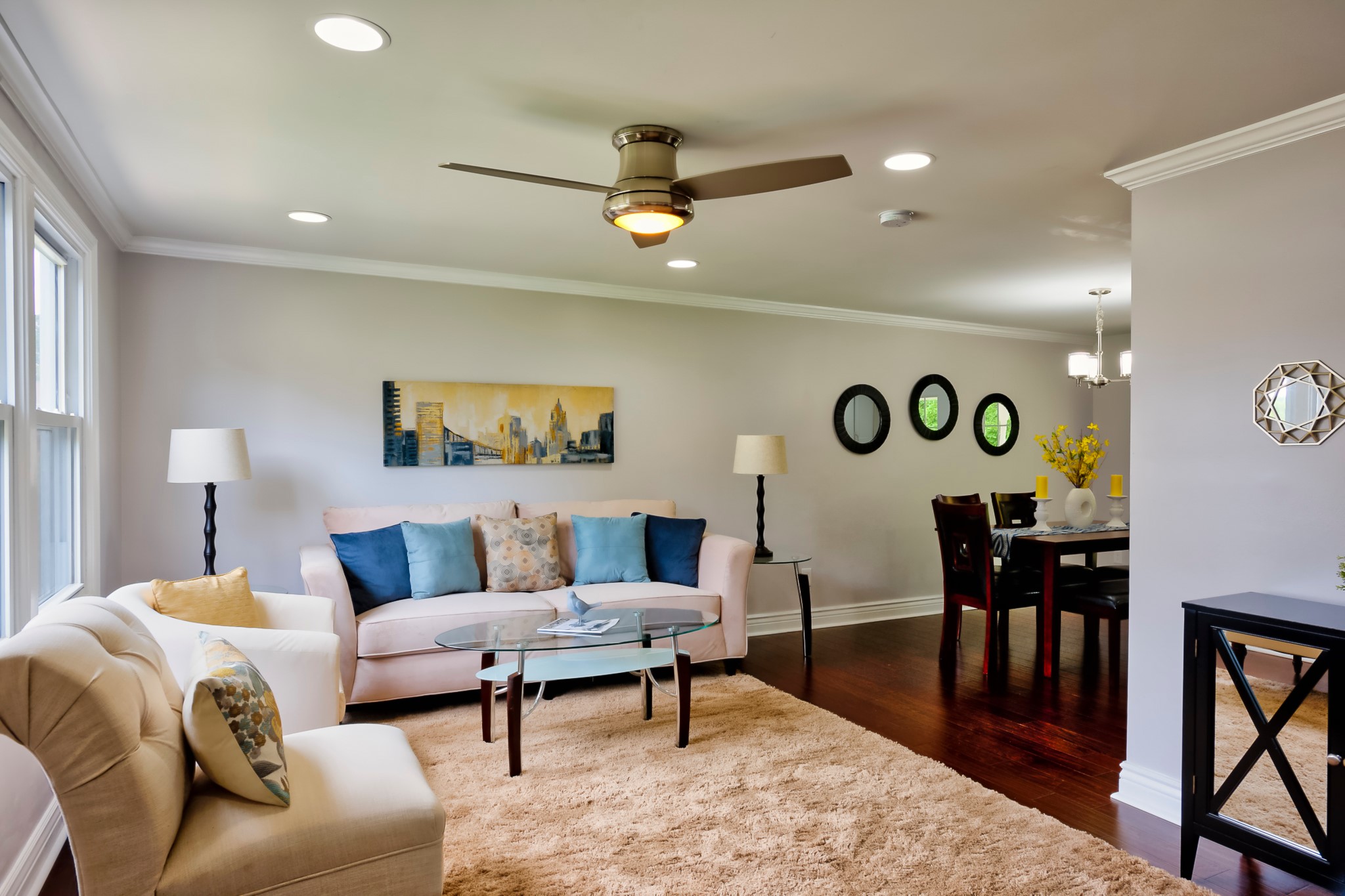 Living room with cream sofa, area rug and dark hardwood floors in Fair Haven, NY