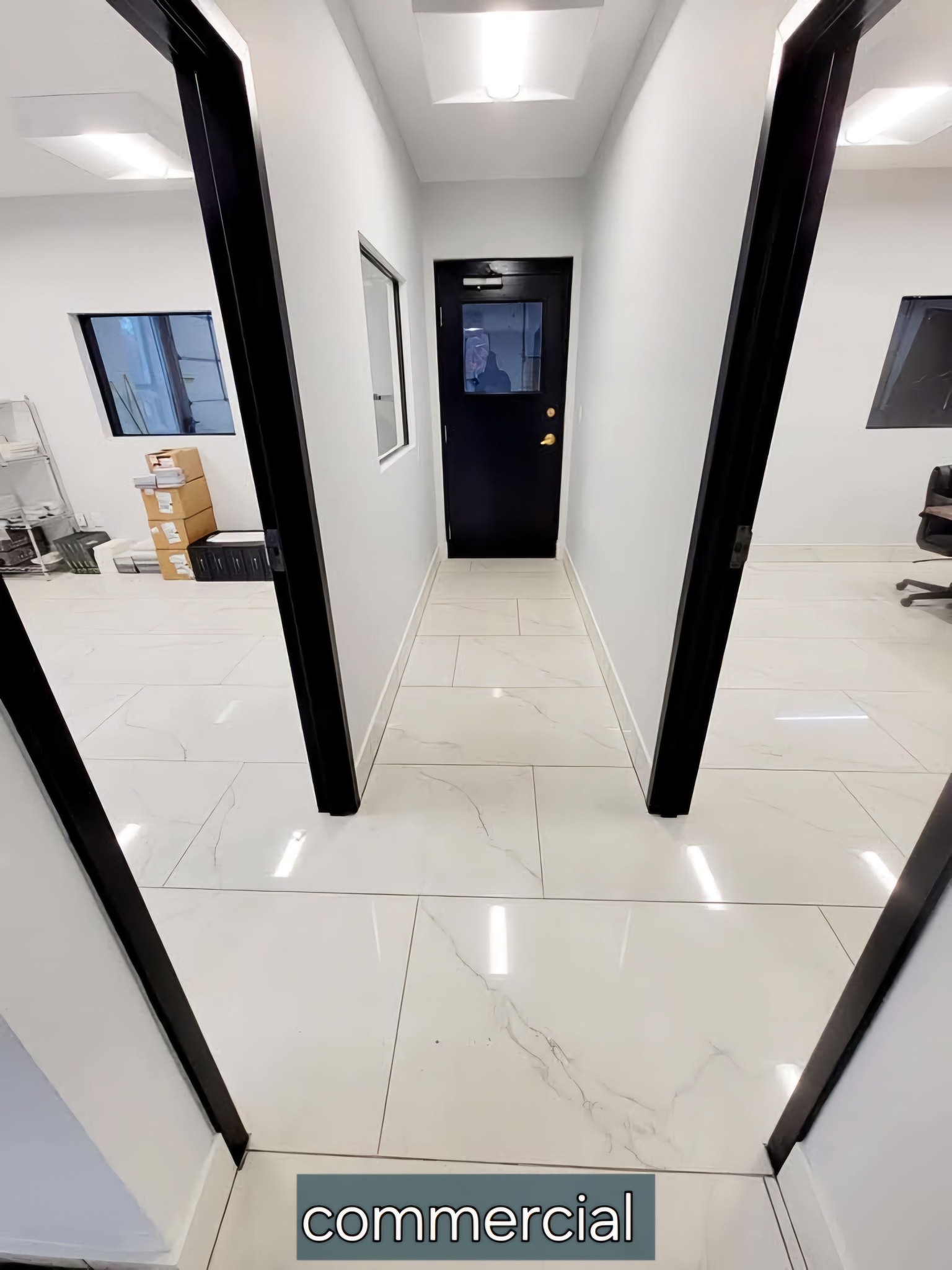 Commercial hallway with white floor tiles and black framed door and partitions in Ontario, NY
