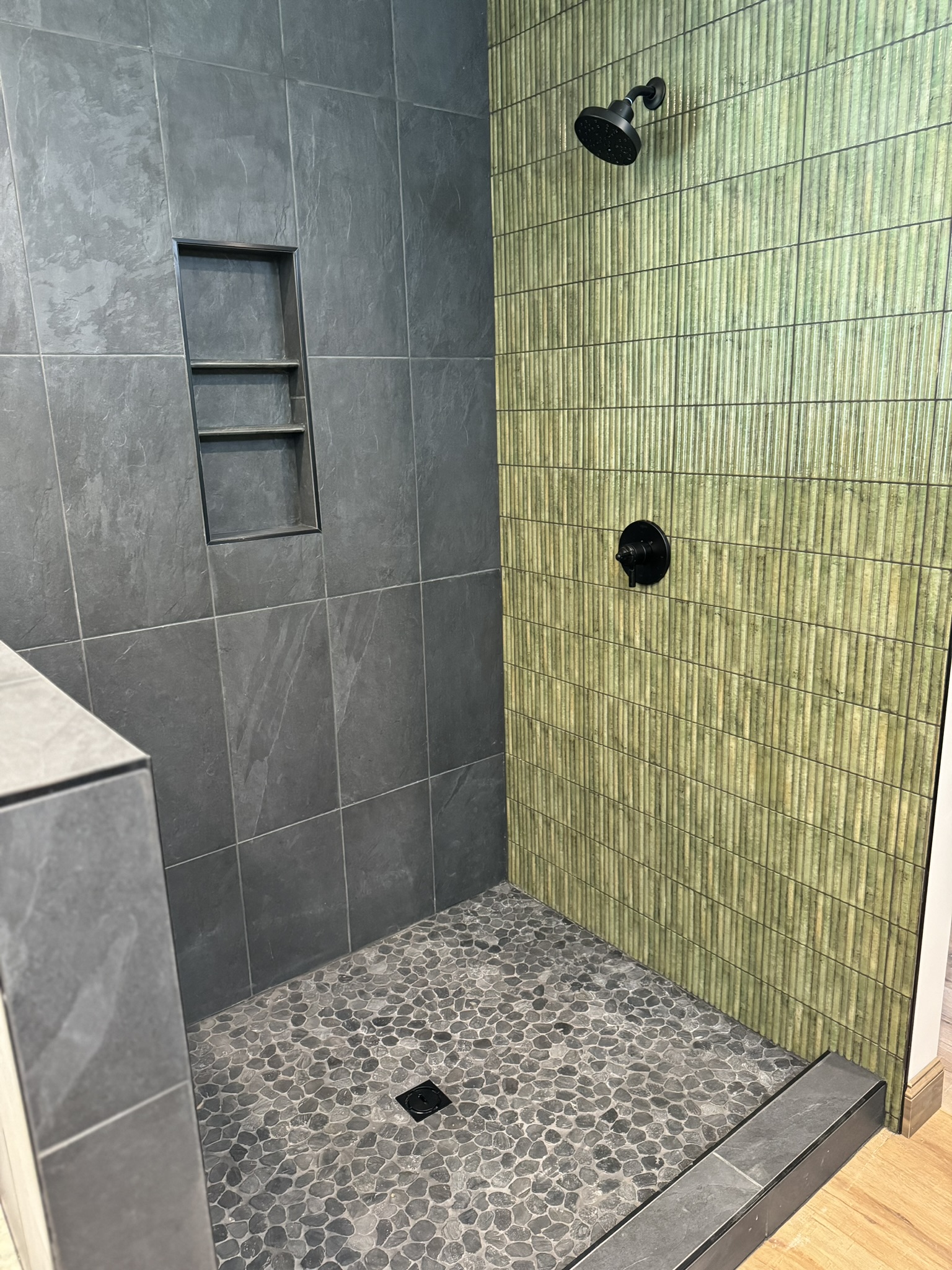 Shower with gray tile walls and green vertical accent tile wall in Sodus, NY