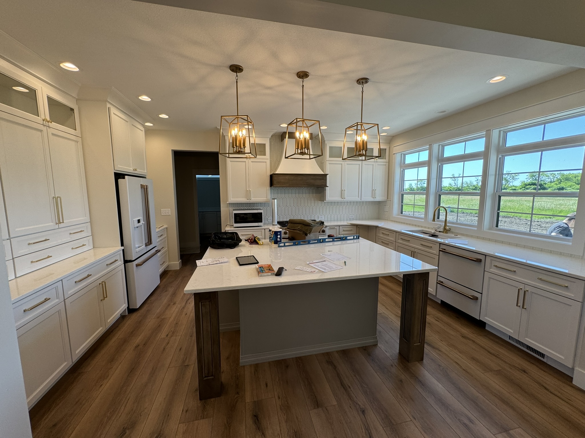 Bright kitchen with white cabinets, a large island, and many windows in Red Creek, NY