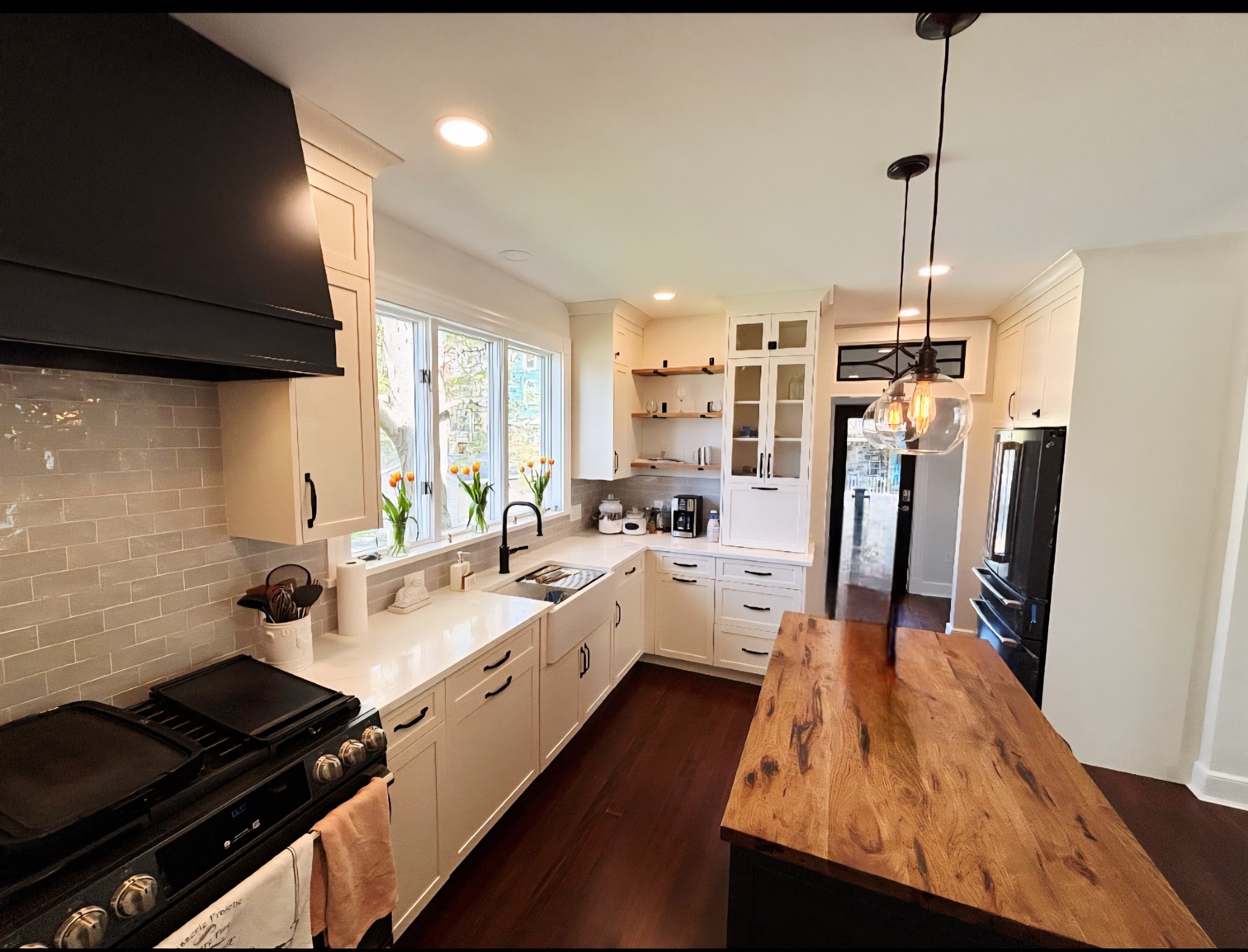 Kitchen with white cabinets farmhouse sink and wooden topped center island area in Baldwinsville, NY
