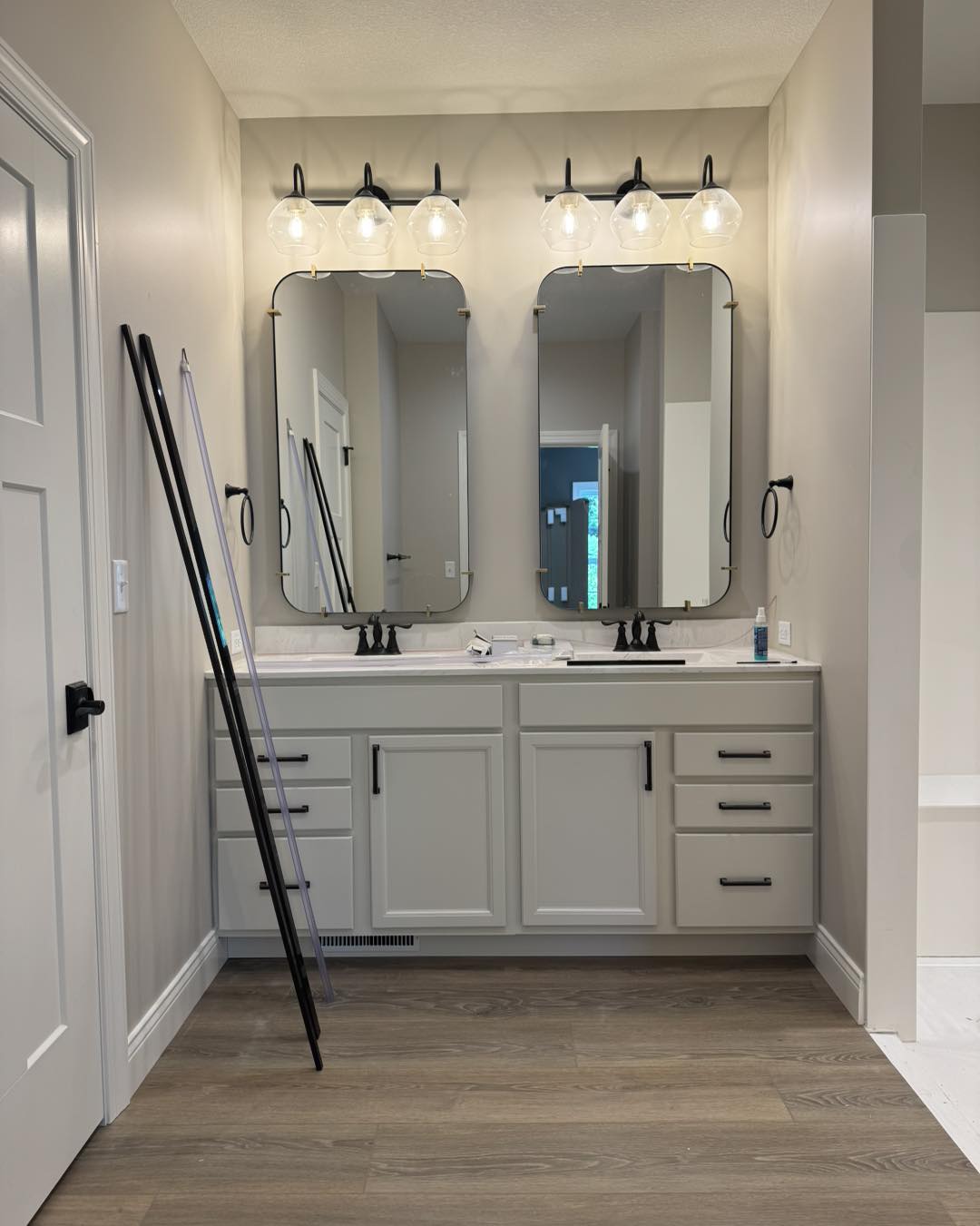 Bathroom vanity with two sinks, gray cabinets and two framed mirrors in Clyde, NY