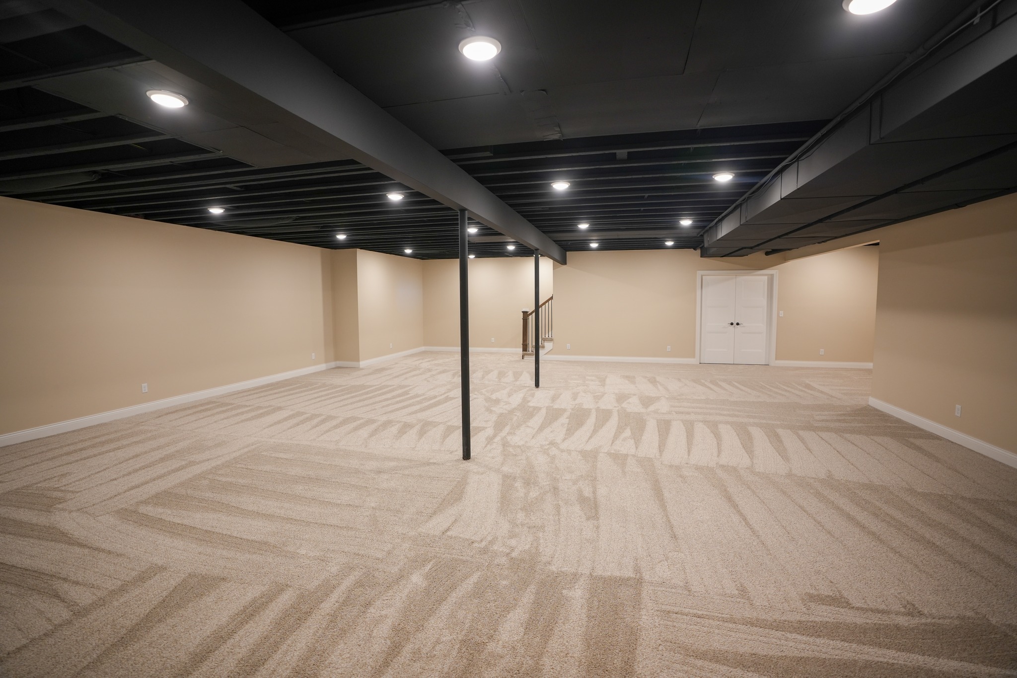 Spacious unfinished basement with neutral carpet and black ceiling beams in Savannah, NY
