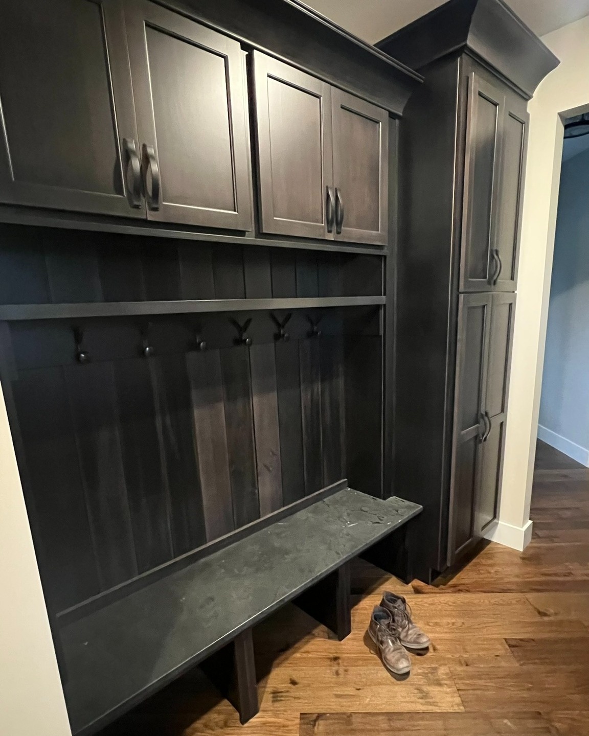 Mudroom entry with a dark wooden bench and coat rack storage unit in Sodus Point, NY