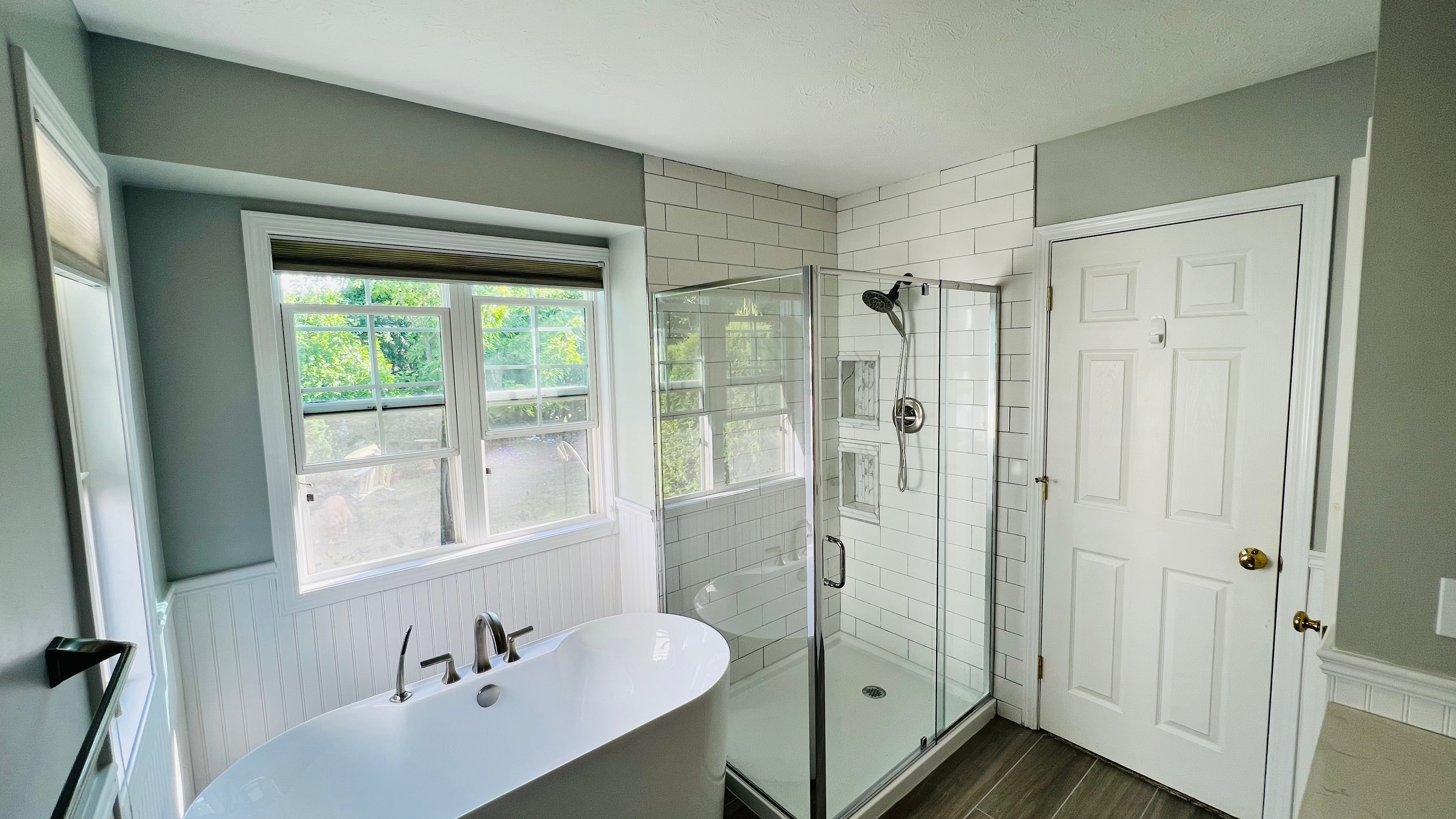 Bathroom interior with a freestanding white tub and a glass shower stall in Butler, NY