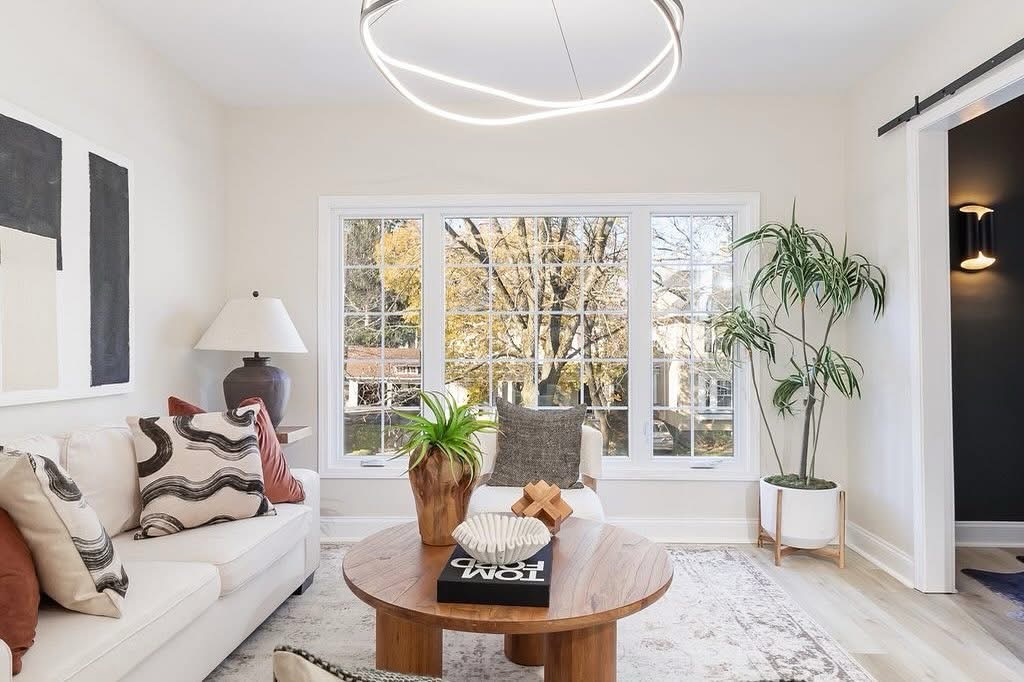Living room with round wood coffee table, white sofa, and window view in Red Creek, NY