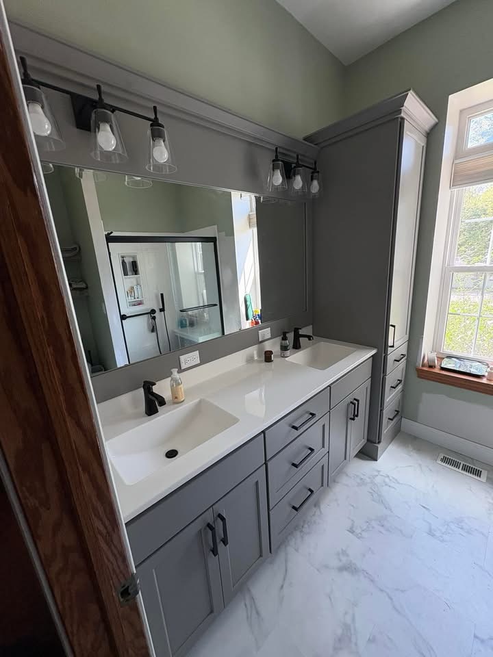 Bathroom double vanity with gray cabinets marble floor and large mirror in Baldwinsville, NY